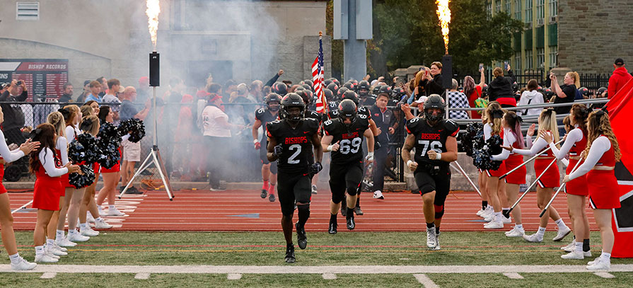 OWU Football team running onto field